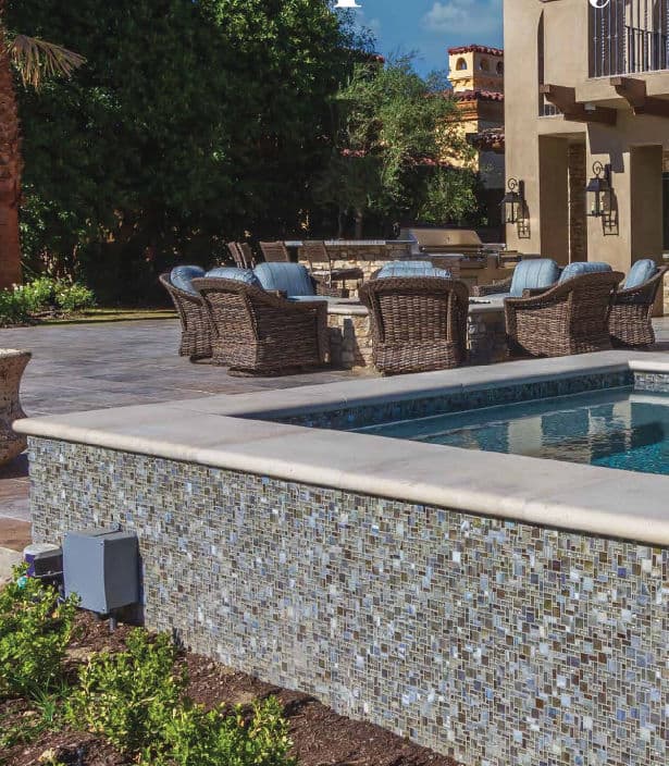 Luxury outdoor area featuring a pool, patio seating, and lush landscaping.